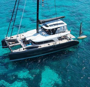 Aerial view of Lucky You Lagoon Sixty5 catamaran in turquoise waters of Italy.