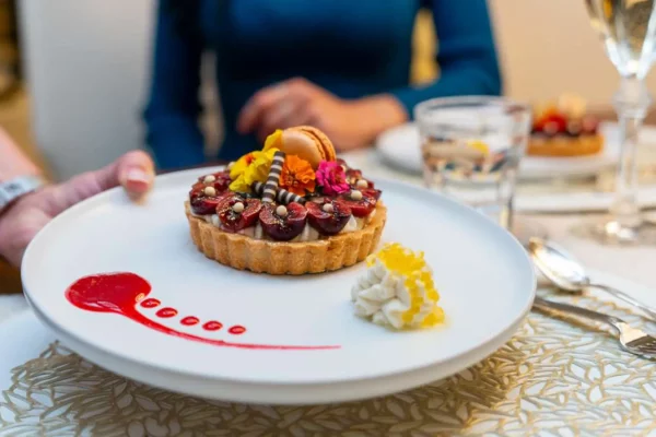A close-up of a chef’s hands plating a fine dining dish on Lucky Lady yacht.
